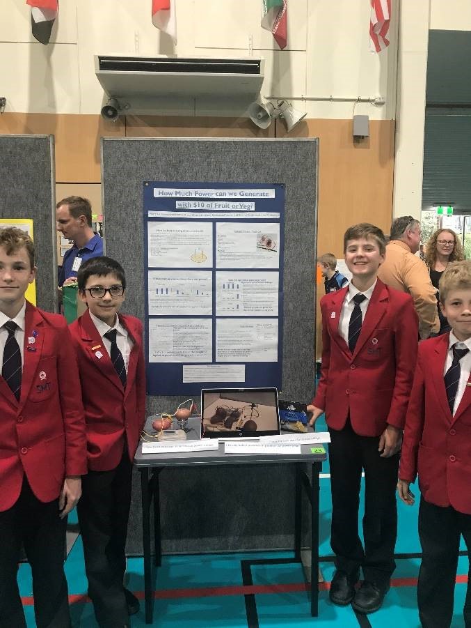 Students standing in front of their winning experiment at 2019 Kids' STEM convention